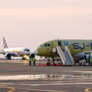 Самолёты МС-21 и SJ-100 на аэропорту с людьми в жилетах безопасности