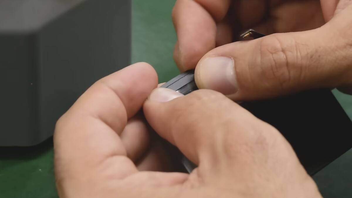 Мужчина собирает аккумулятор iPhone на заводе iFixit
