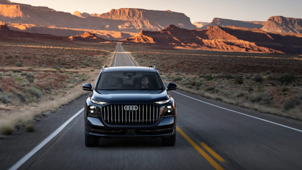 Черная Audi Q9 на пустой дороге у красных скальных формаций