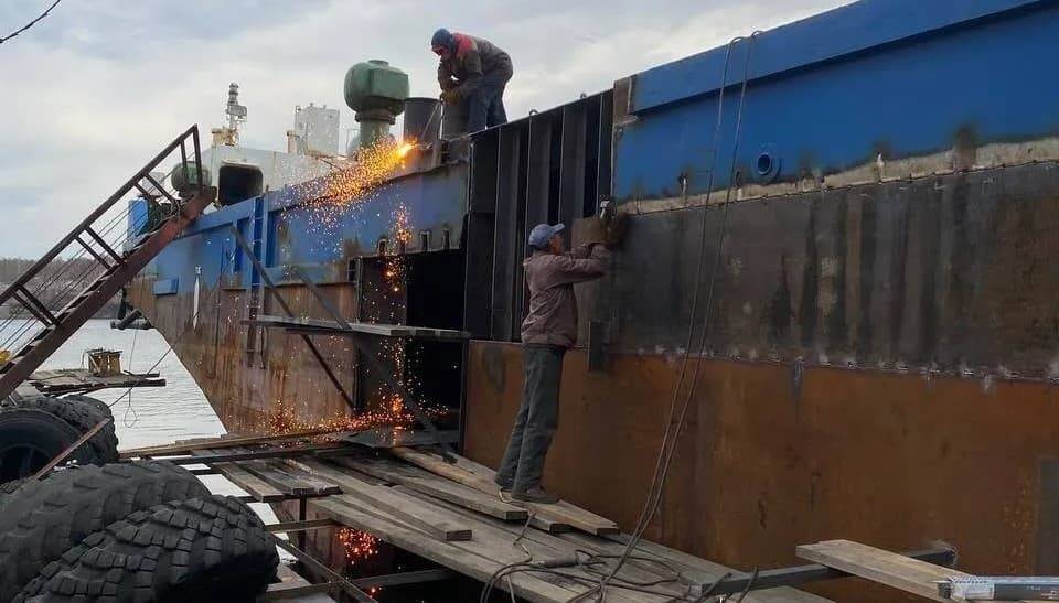 Рабочие на барже проводят ремонтные работы сваркой