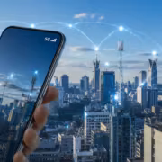 смартфон с 5G и символом связи на фоне города