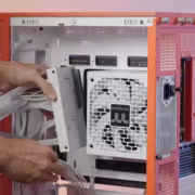 Оператор устанавливает блок питания Thermaltake Dockpower FI в корпус компьютера