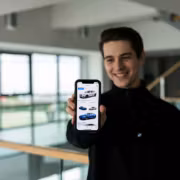Мужчина держит смартфон с интерфейсом BMW с ChatGPT