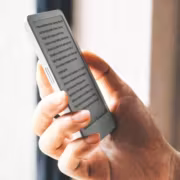 Человек держит небольшой ридер Boox Picco с текстом на экране