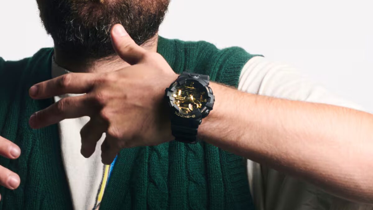 Мужчина показывает часы G-Shock с золотым циферблатом