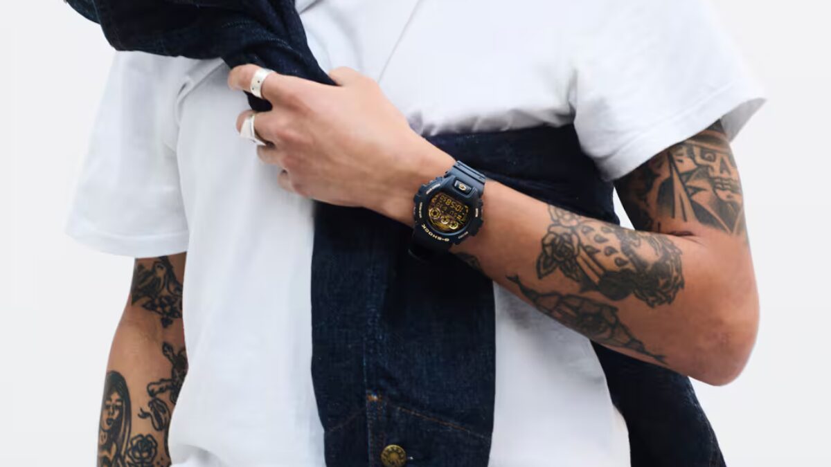 Черный G-Shock с золотым циферблатом на руке человека