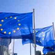 Флаги Европейского парламента на фоне неба и зданий
