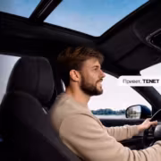 Мужчина в автомобиле за рулём, Tenet T8, салон, приборная панель, дисплей, стеклянная крыша