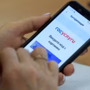 Мужчина держит смартфон с приложением Госуслуги