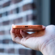Палец держит смартфон iPhone 18 Pro Max с розовым корпусом
