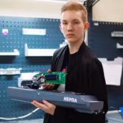 Школьник держит блок управления для беспилотного катера Нерпа