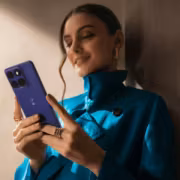 Женщина в голубой куртке использует смартфон Motorola Edge 70 Max
