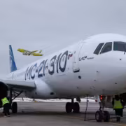 самолет МС-21 на стоянке у терминала с грузчиками