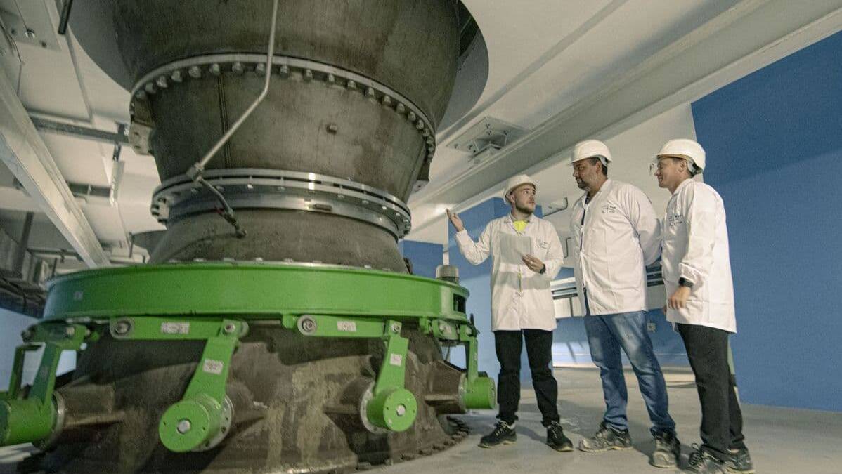 Три инженера в касках обсуждают насос высотой с 5-этажный дом на АЭС Аккую