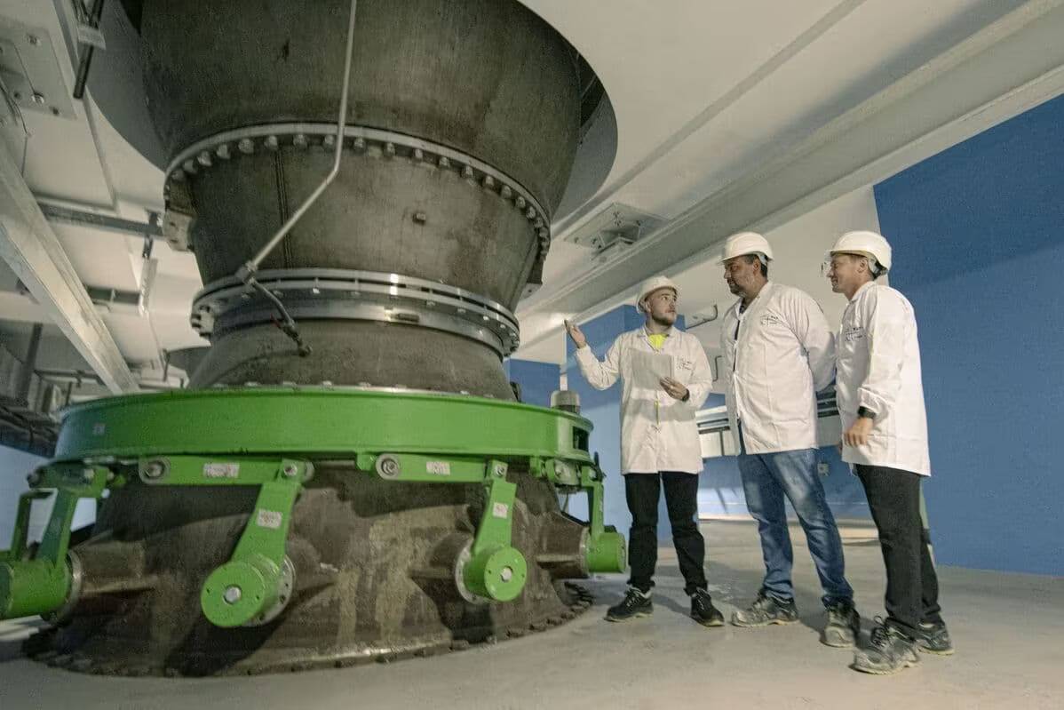 Три инженера в касках обсуждают насос высотой с 5-этажный дом на АЭС Аккую
