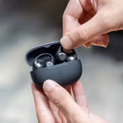 Человек держит наушники Shokz OpenDots 2 в руке