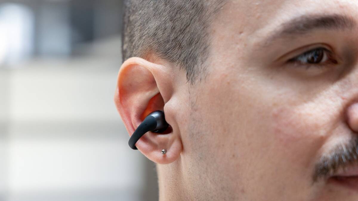 Человек слушает в наушниках Shokz OpenDots 2