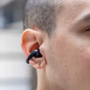 Человек слушает в наушниках Shokz OpenDots 2