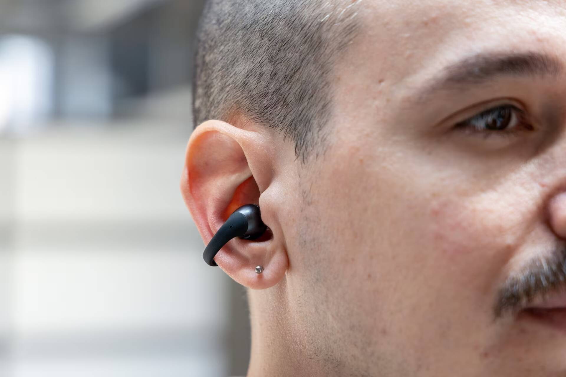 Человек слушает в наушниках Shokz OpenDots 2