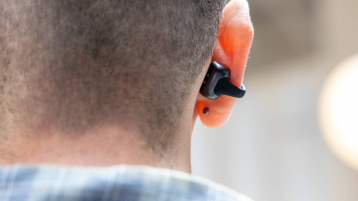 Человек в ухе использует наушники Shokz OpenDots 2