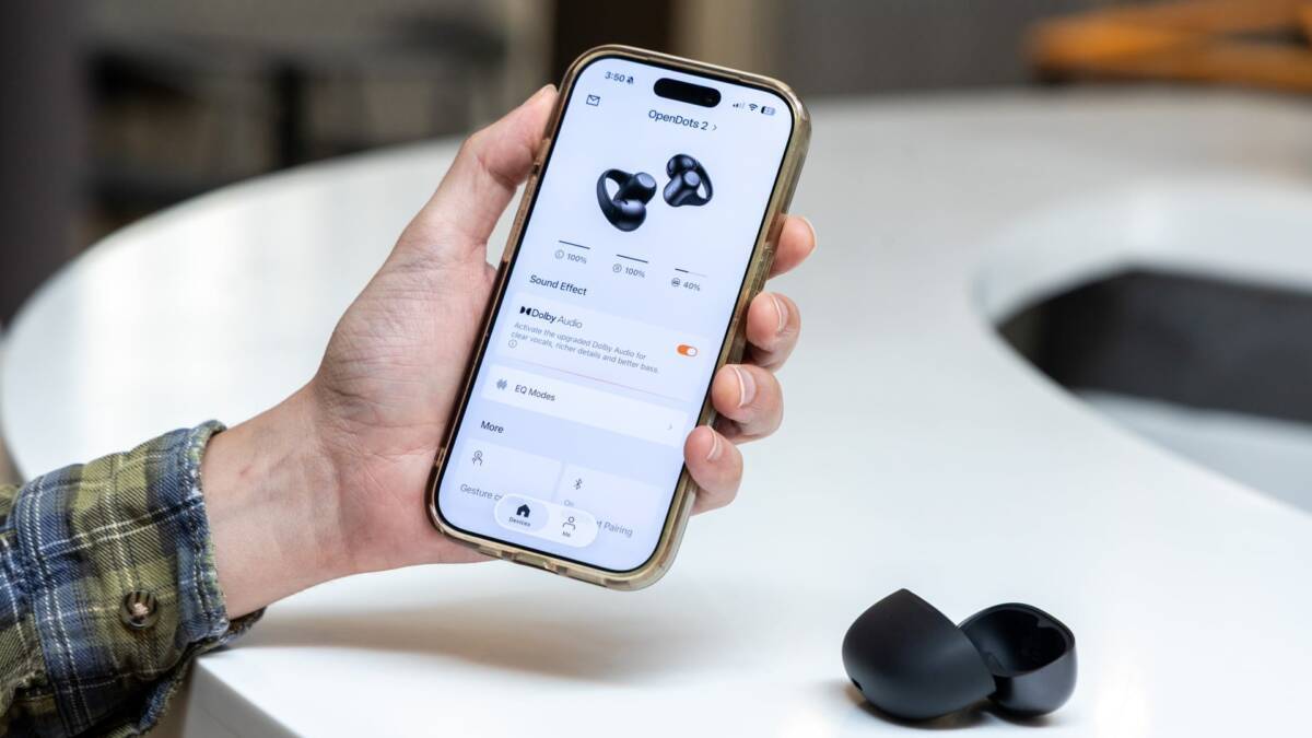 Человек держит смартфон с настройками Shokz OpenDots 2