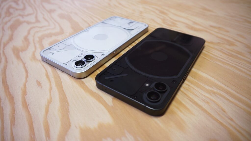 Черный и серебристый смартфон Nothing Phone 1 на деревянном столе