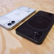 Черный и серебристый смартфон Nothing Phone 1 на деревянном столе