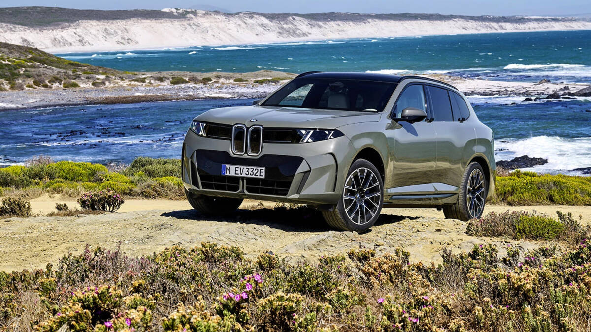 Кроссовер BMW X5 на берегу моря с цветущими кустами