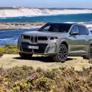 Кроссовер BMW X5 на берегу моря с цветущими кустами