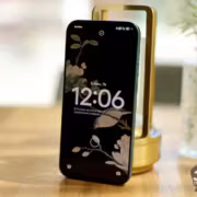 Смартфон Xiaomi на деревянном столе рядом с лампой и вазой