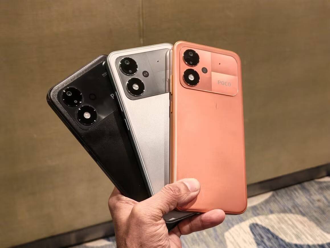 Три Poco M8 Power телефона разных цветов в руке