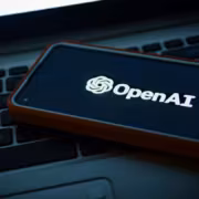смартфон с логотипом OpenAI на экране ноутбук клавиатура
