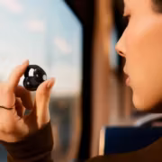 Женщина держит наушник Sennheiser Accentum Clip в руке