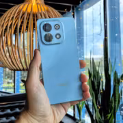 Рука держит голубой смартфон Huawei nova Y74 в помещении