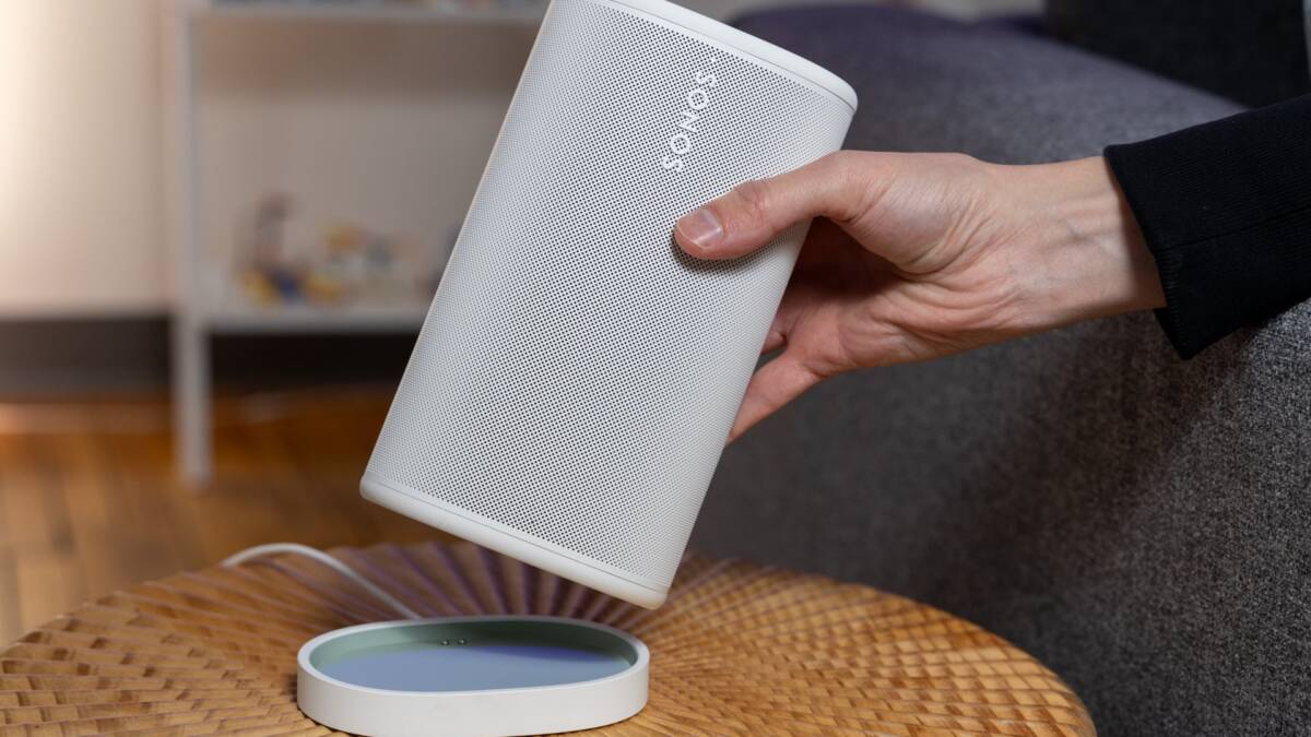 Колонка Sonos белая держится в руке в доме