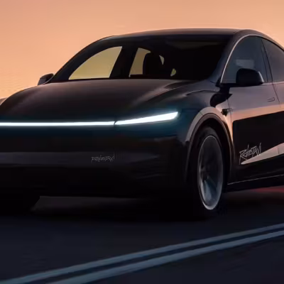 Электромобиль Tesla Model Y на дороге вечером
