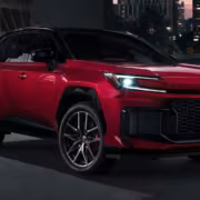 Красный кроссовер Toyota RAV4 Highlander на улице в сумерках