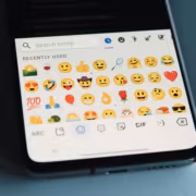 Смартфон с открытым приложением для сообщений emoji с яркой панелью