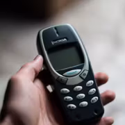Маленький кнопочный телефон Nokia в руке пользователя