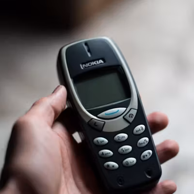 Маленький кнопочный телефон Nokia в руке пользователя