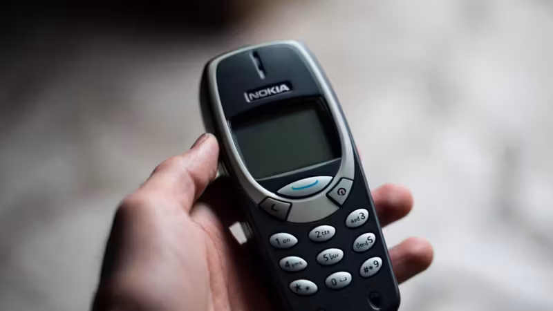 Маленький кнопочный телефон Nokia в руке пользователя