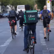 люди на велосипедах в городе с курьером Uber Eats