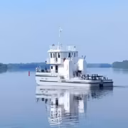 белая лодка на воде с мачтой и кабиной