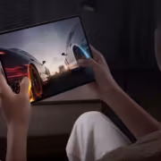 Планшет vivo Pad 5c в руке человека на заднем плане темная комната