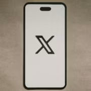 Смартфон с логотипом X и названием статьи