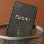 Разбитый смартфон Xiaomi, видно логотип Xiaomi на экране