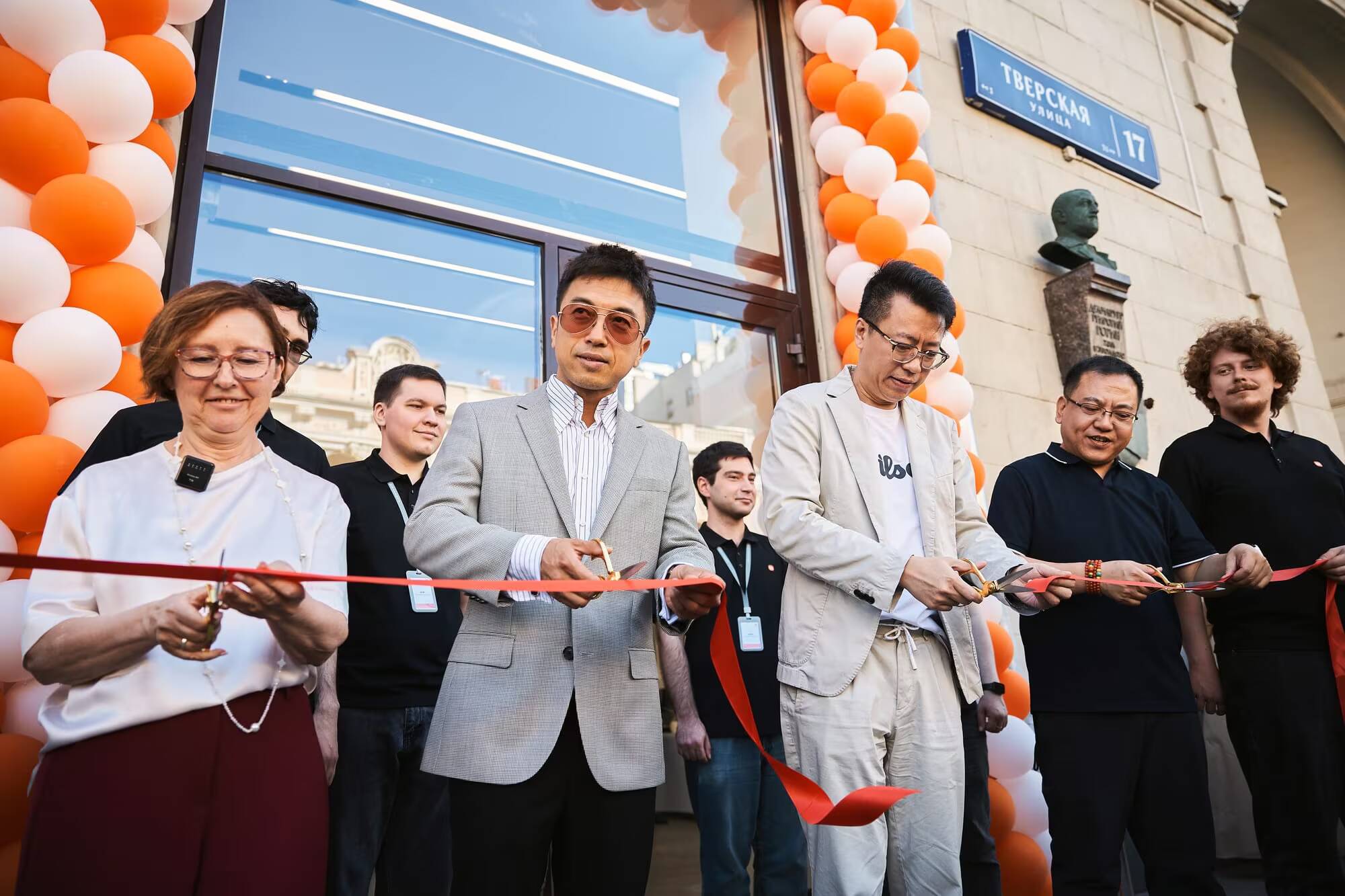 Xiaomi открыла флагманский магазин на Тверской в Москве 1 люди разрезают красную ленту перед магазином Xiaomi на Тверской улице