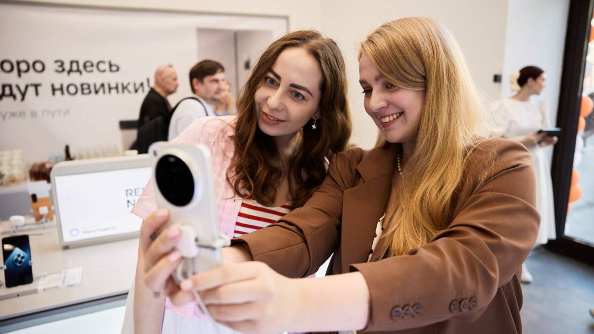 Xiaomi открыла флагманский магазин на Тверской в Москве 8 Две женщины фотографируются в магазине Xiaomi на Тверской