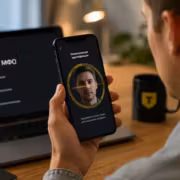 Мужчина использует мобильный телефон для биометрической идентификации Т-Банк