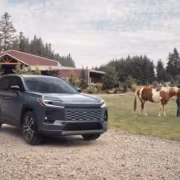 Автомобиль Toyota на грунтовой дороге возле фермы с лошадью